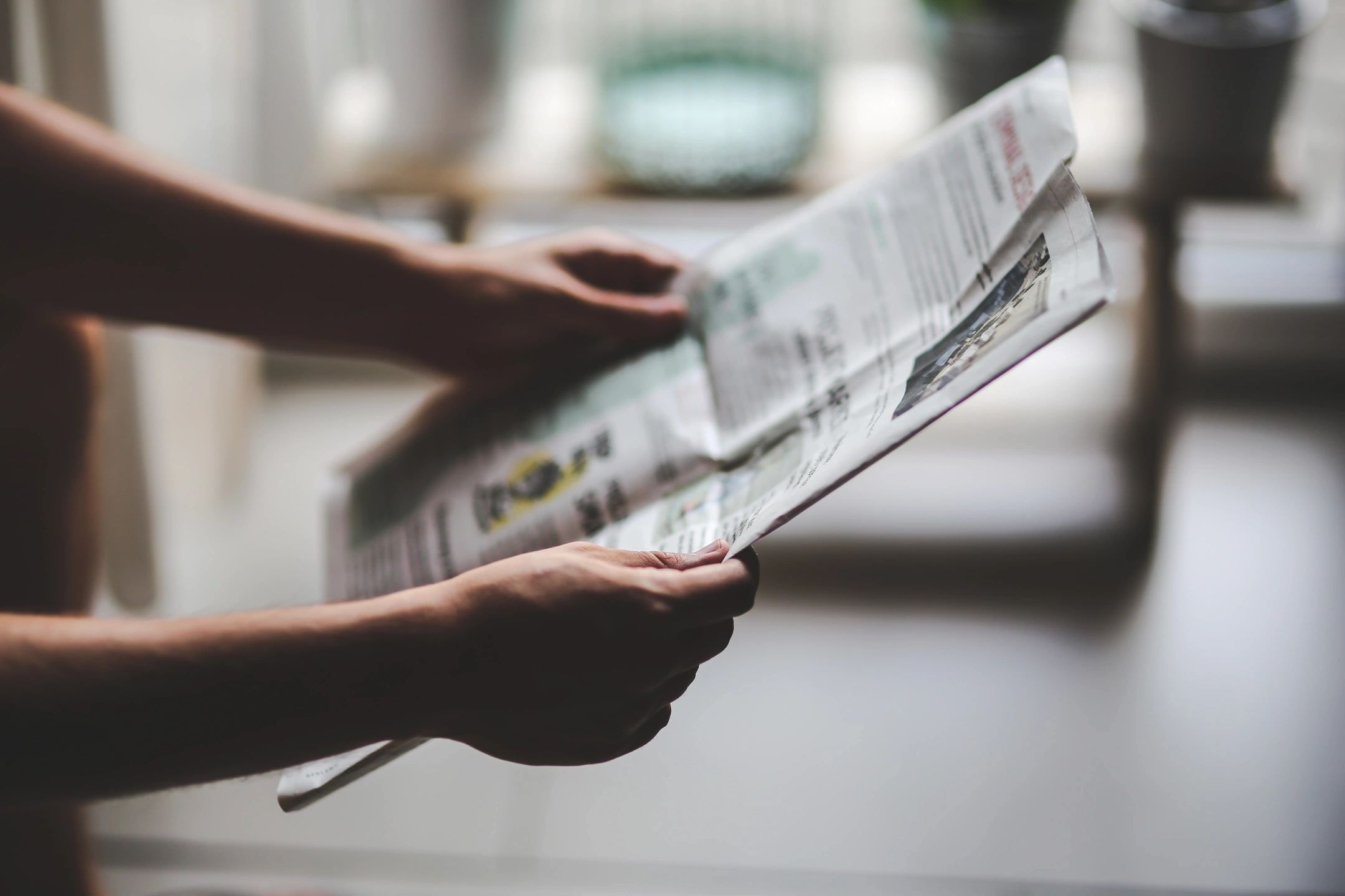Person reviewing a newspaper document